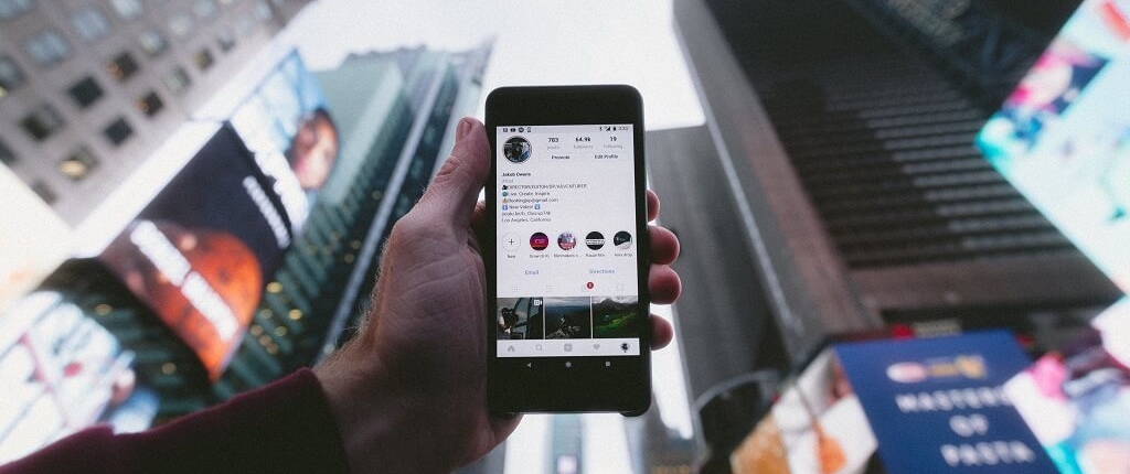 Smartfon z aplikacją Instagram na tle budynków w centrum miasta